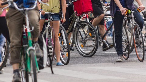 Menschen sitzen auf Fahrrädern, die Köpfe sind nicht zu sehen.