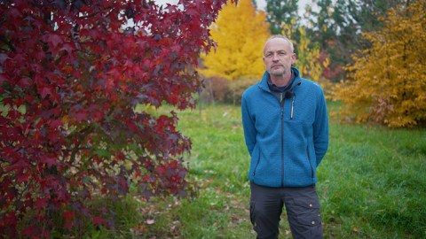 Dr. Pietzarka steht inmitten von Bäumen im Forstbotanischen Garten Tharandt.