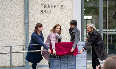 Vier Frauen enthüllen eine Tafel.