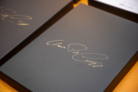 Eine schwarze Schachtel, darauf der goldene Schriftzug in Schreibschrift "Claus-Peter Lumpp"