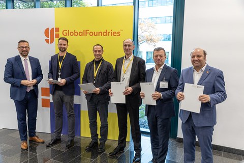 Fünf Herren nebeneinander mit Urkunden in der Hand, links daneben Staatsminister Dulig, dahinter eine Fotowand mit der Aufschrift "GlobalFoundries"