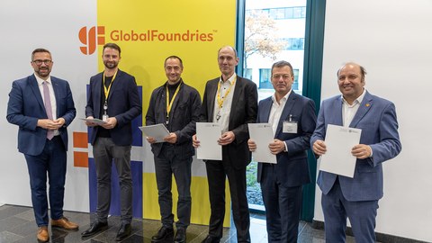 Fünf Herren nebeneinander mit Urkunden in der Hand, links daneben Staatsminister Dulig, dahinter eine Fotowand mit der Aufschrift "GlobalFoundries"