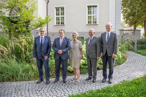 Gruppenbild von fünf Personen - einer Frau und vier Männern - im Garten vor dem Rektoratsgebäude der TU Dresden.