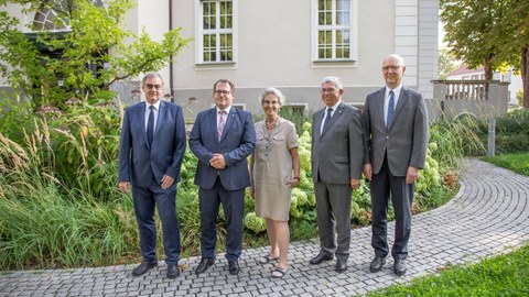 Gruppenbild von fünf Personen - einer Frau und vier Männern - im Garten vor dem Rektoratsgebäude der TU Dresden.
