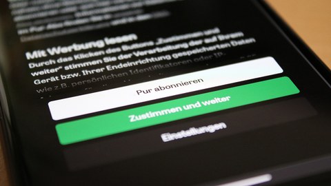 Ein Handydisplay auf dem eine Cookie- und Werbebanner zu sehen ist mit den Buttons "Pur abonnieren" in weiß, "Zustimmen und weiter" in grün und "Einstellungen" in dunkelgrau