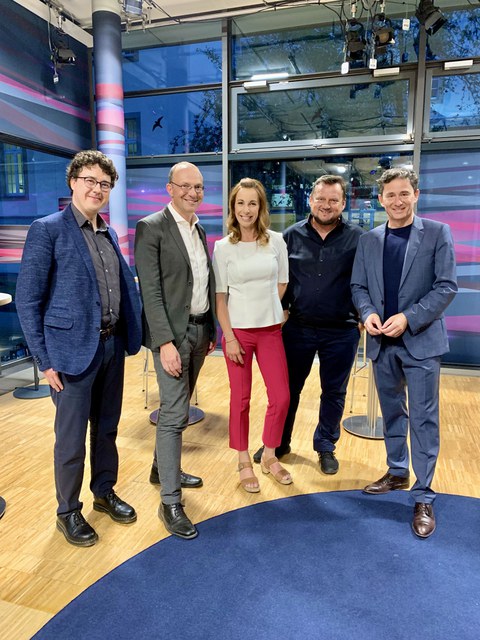 Gruppenbild mit 5 Personen in einem Fernsehstudio.