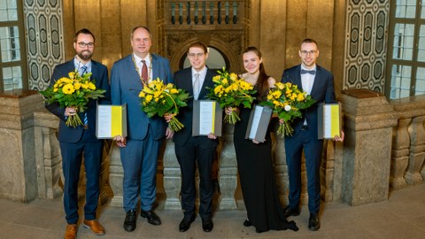 Preisträger:innen und Oberbürgermeister Hilbert mit Urkunden und Blumen