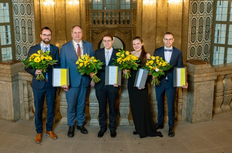 Preisträger:innen und Oberbürgermeister Hilbert mit Urkunden und Blumen