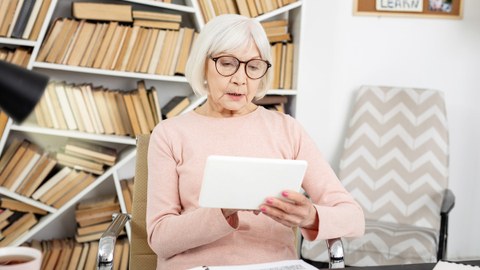 Ältere Dame bedient ein Tablet