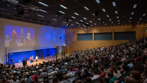 Blick in einen Hörsaal mit Publikum.