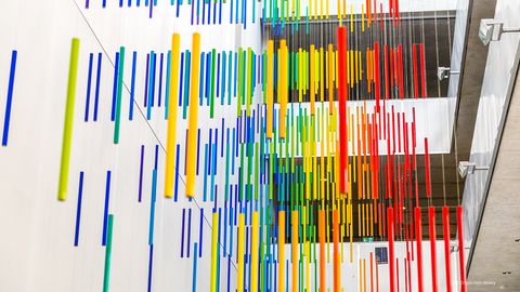 Kunstinstallation von Roland Fuhrmann mit regenbogenfarbig hängenden Röhren im Chemieneubau.