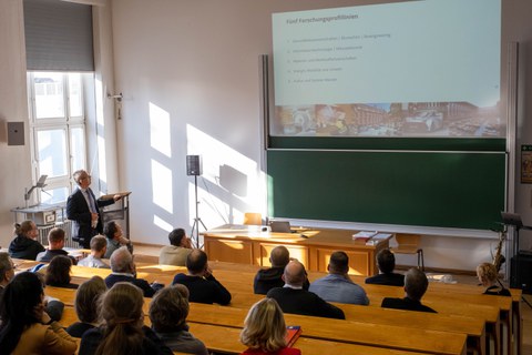 Personen folgen einem Vortrag mit einer Präsentation