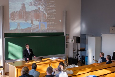 Personen folgen einem Vortrag mit einer Präsentation.