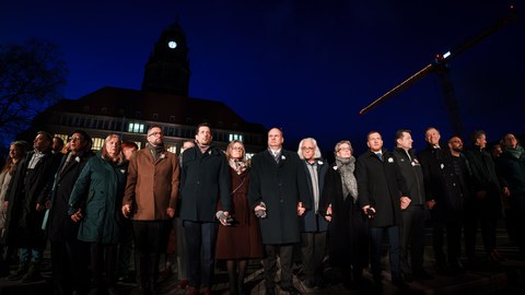 Fotoaufnahme von mehreren Menschen, die sich an den Händen halten und eine Menschenkette bilden.