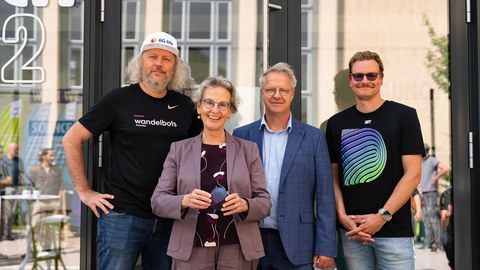 Fotoaufnahme von Prof. Frank Fitzek, Prof. Holger Boche, Prof.in Ursula Staudinger und Florian Sägebrecht (v. l. n. r.), die vor dem Modulgebäude launchhub42 stehen.