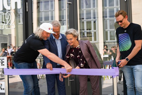 Fotoaufnahme von Prof. Frank Fitzek, Prof. Holger Boche, Prof.in Ursula Staudinger und Florian Sägebrecht (v. l. n. r.) beim Durchschneiden eines Bandes zur Eröffnung eines Gebäudes.