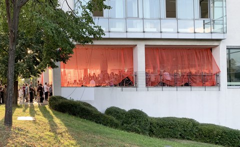 Fotoaufnahme von zahlreichen Menschen, die sich im Eingangsbereich eines Bürogebäudes aufhalten.