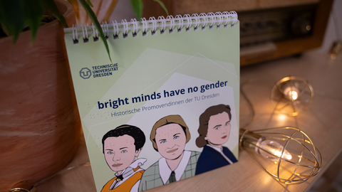 Fotoaufnahme eines Tischkalenders, das gezeichnete Porträts vondrei Frauen zeigt. Der Kalender enthält den Schriftzug "bright minds have no gender".