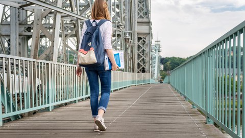 Mensch läuft über Brücke