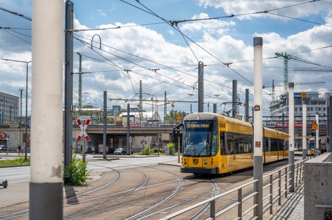 Foto der Infrastruktur am Hauptbahnhof. Die Straßenbahn "3" nach "Wilder Mann" passiert gerade die Straßenbahnkreuzung.