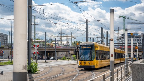 Foto der Infrastruktur am Hauptbahnhof. Die Straßenbahn "3" nach "Wilder Mann" passiert gerade die Straßenbahnkreuzung.