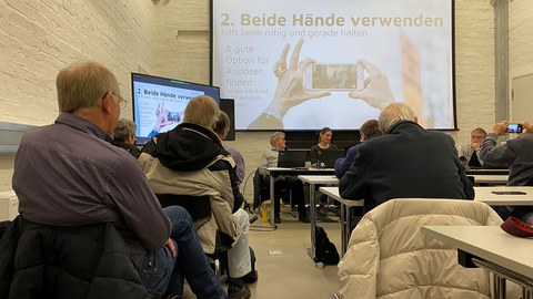 Fotografieren mit dem Handy: Hörerinnen und Hörer der Seniorenakademie machen sich dazu bei einem Vortrag im Medienkulturzentrum schlau.