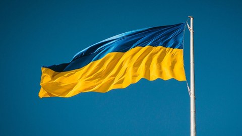 Eine ukrainische Flagge an einem Fahnenmast flattert im Wind.