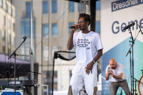 Fotoaufnahme des Musikers Ezé mit einem Mikrofon in der Hand.