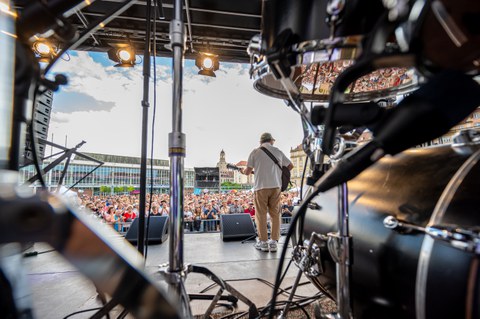 Foto des Musikers Bosse auf der Bühne. Das Foto zeigt ihn von hinten sowie die Menschen, die vor der Bühne stehen.