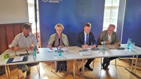 Sachsens Ministerpräsident Michael Kretschmer (2.v.r.), TUD-Rektorin Prof.in Ursula Staudinger (2.v.l.), Jan Gerken, Kanzler der TU Dresden (r.) und Silvio Ziesemer, Bürgermeister der Stadt Tharandt (l.) bei der Unterzeichnung der Urkunde.