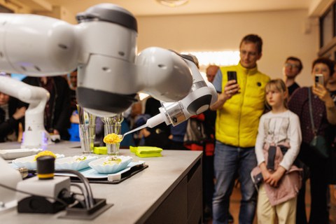 Foto von mehreren Menschen, die in der CeTIBAR einem Roboter zuschauen.