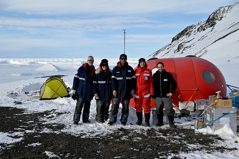 Gruppenfoto mit fünsch Menschen vor dem Camp.
