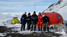 Gruppenfoto mit fünsch Menschen vor dem Camp.