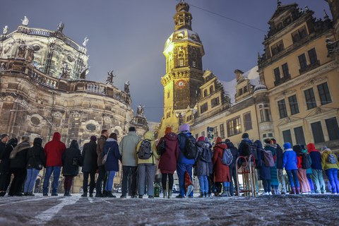 Foto von Menschen, die gemeinsam Hand in Hand eine Kette bilden vor Gebäuden der Dresdner Altstadt.