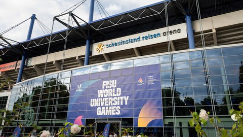 Foto von der Schauinsland Reisen Arena in Duisburg, an deren Fassade ein großes Banner auf die World University Games verweist.