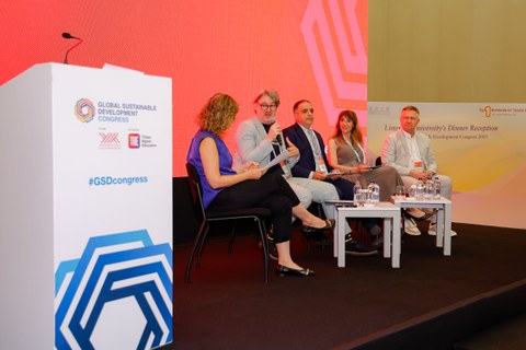 Fotoaufnahme von fünf Personen auf einer Bühne eines Panels beim GSDC. Die zweite Person von links ist André Lindner von der TU Dresden.