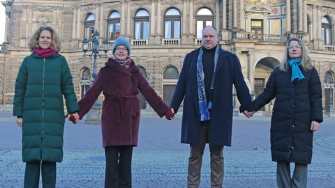 Foto von Nora Schmid, Prof.in Ursula Staudinger, Dresdens Oberbürgermeister Dirk Hilbert und Bürgermeisterin Annekatrin Klepsch auf dem Theaterplatz in Dresden mit der Semperoper im Hintergrund.