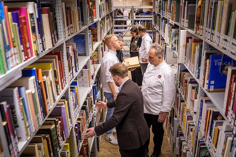 Erich Schwingshackl, Andreas Rieger, Christian Bau und Nils Henkel stöbern in den Regalen. 