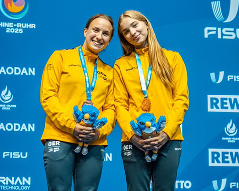Foto der Turmspringerinnen Lena Hentschel und Jette Müller, die ihre Medaillen auf dem Siegertreppchen präsentieren.