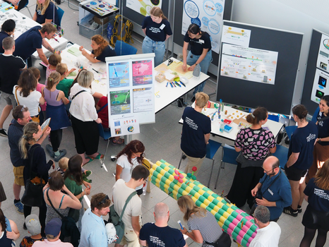 Foto von mehren Tischen, an denen Forscher:innen im CMCB den Besucher:innen der LNdW von ihrer Arbeit erzählen.
