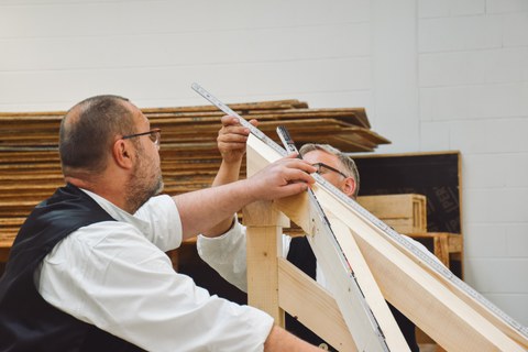 Zimmerer bei der Arbeit mit Holz.