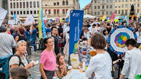 Foto vom Stand der TU Dresden beim Gastmahl 2026 auf dem belebten Dresdner Neumarkt.
