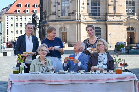Foto von mehreren Personen, die auf dem Dresdner Neumarkt an einem Tisch sitzen. Von links: Anne-Kathrin Schladitz (Chief of Staff GlobalFoundries), Prof.in Ursula M. Staudinger (Rektorin der TU Dresden), Dr. Eva Sturm (Vorständin Cellex Stiftung), Prof. Gerhard Ehninger (Vorsitzender des Stiftungsrats der Cellex Stiftung), Maria Noth (Geschäftsführerin der Stiftung Frauenkirche Dresden) und Ulrike Leßmann (Intendantin tjg. theater junge generation).