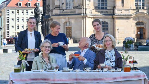 Foto von mehreren Personen, die auf dem Dresdner Neumarkt an einem Tisch sitzen. Von links: Anne-Kathrin Schladitz (Chief of Staff GlobalFoundries), Prof.in Ursula M. Staudinger (Rektorin der TU Dresden), Dr. Eva Sturm (Vorständin Cellex Stiftung), Prof. Gerhard Ehninger (Vorsitzender des Stiftungsrats der Cellex Stiftung), Maria Noth (Geschäftsführerin der Stiftung Frauenkirche Dresden) und Ulrike Leßmann (Intendantin tjg. theater junge generation).