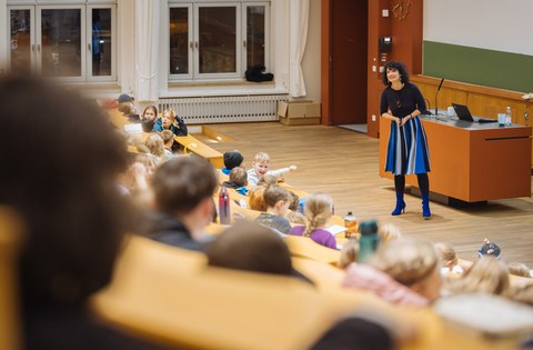 Foto von Prof.in Stefanie Speidel in einem Hörsaal der TU Dresden. In den Sitzreihen befinden sich Kinder.