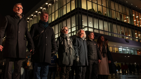 Fotoaufnahme von mehreren Personen, darunter TUD-Rektorin Prof. Ursula M. Staudinger, die sich vor dem Dresdner Kulturpalast die Hände reichen und eine Menschenkette bilden.