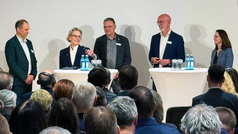 Foto von Frank Bösenberg (Geschäftsführer von Silicon Saxony), Prof. Ursula M. Staudinger (Rektorin TUD), Dr. Harald Lück (stellv. Sprecher der ET-Scientific-Collaboration), Prof. Christian Stegmann (wissenschaftlicher Co-Leiter der laufenden Machbarkeitsstudie) und Prof. Heike Graßmann (Staatssekretärin im SMWK) bei einer Podiumsdiskussion an Stehtischen.