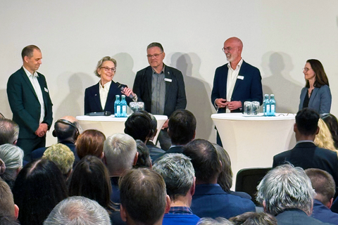 Foto von Frank Bösenberg (Geschäftsführer von Silicon Saxony), Prof. Ursula M. Staudinger (Rektorin TUD), Dr. Harald Lück (stellv. Sprecher der ET-Scientific-Collaboration), Prof. Christian Stegmann (wissenschaftlicher Co-Leiter der laufenden Machbarkeitsstudie) und Prof. Heike Graßmann (Staatssekretärin im SMWK) bei einer Podiumsdiskussion an Stehtischen.