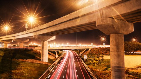 The photo shows a blurred view of the lights and the fast-moving traffic on a motorway at night.