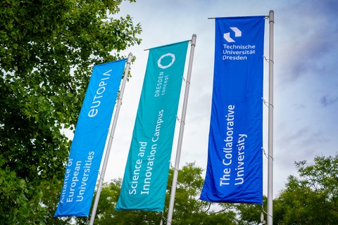 Foto von Fahnen auf dem Campus in den TUD-Farben zu EUTOPIA, Science and Innovation Campus und The Collaborative University.